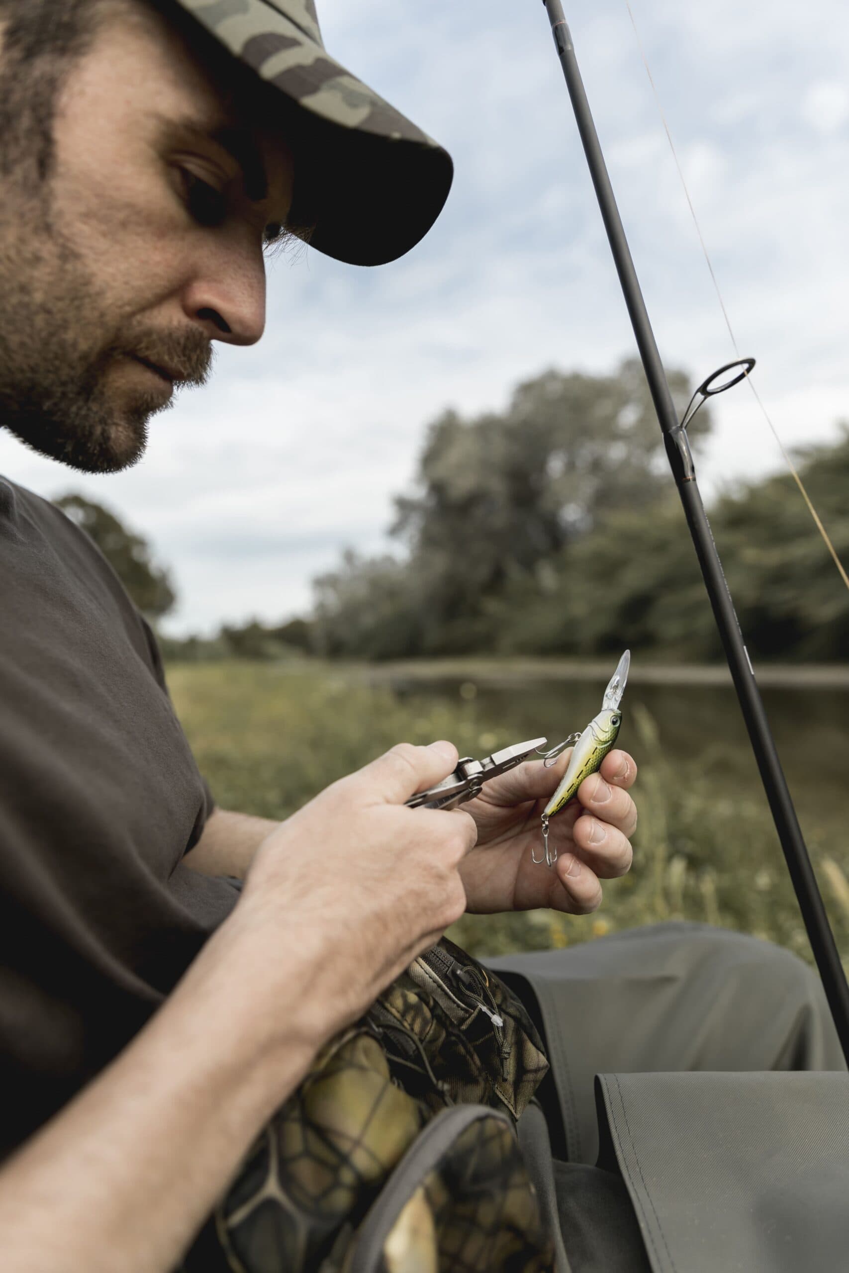 Pescatore che prepara l'amo da pesca su una barca al tramonto